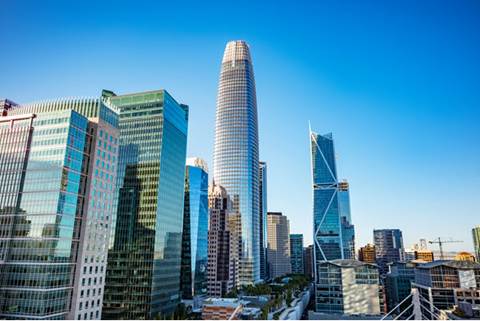 Aerial view rendering of building exterior with city in the background.