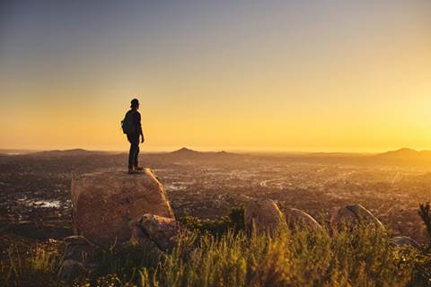 Hiker standing on a boulder.