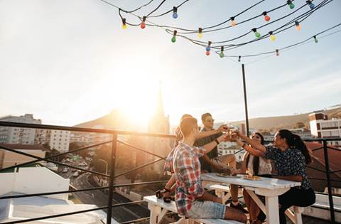 View of city from balcony with patio table at sunset.