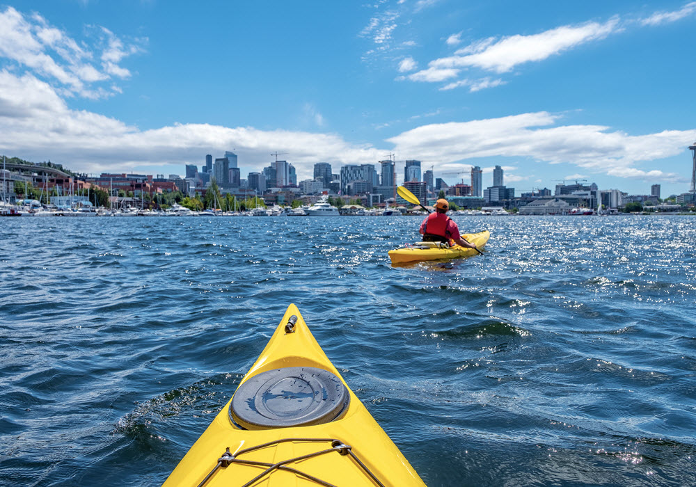 Kayaks on Lake Union in Seattle, Washington with skyline in the background.