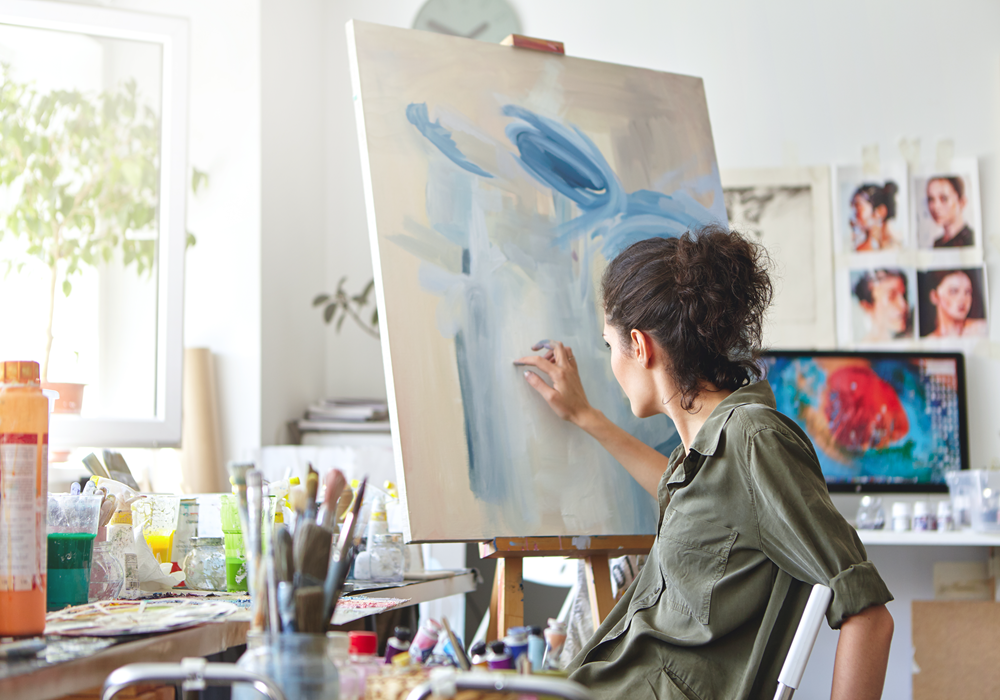 Woman practices her new painting hobby in her apartment home.