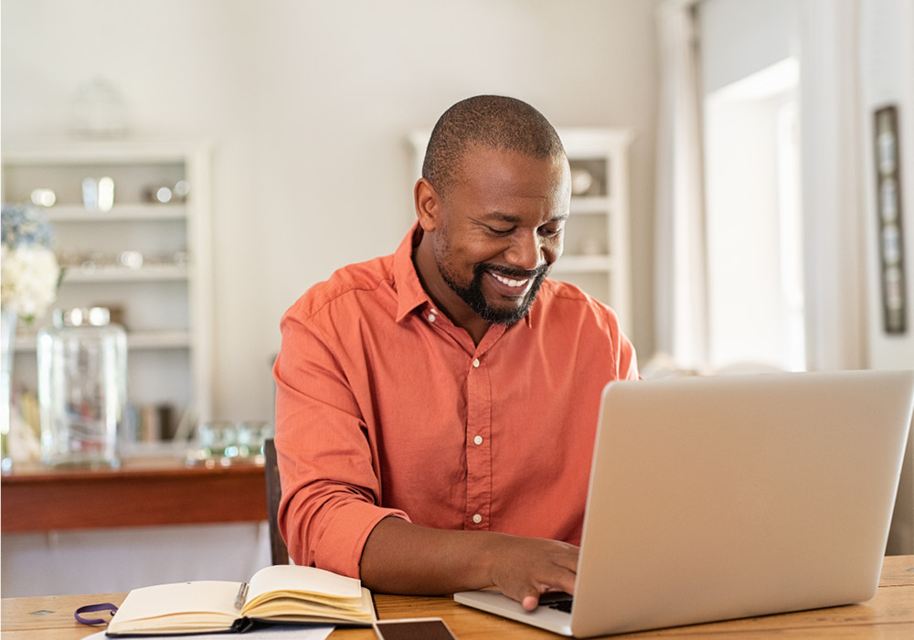 Man learning on his laptop in his apartment home