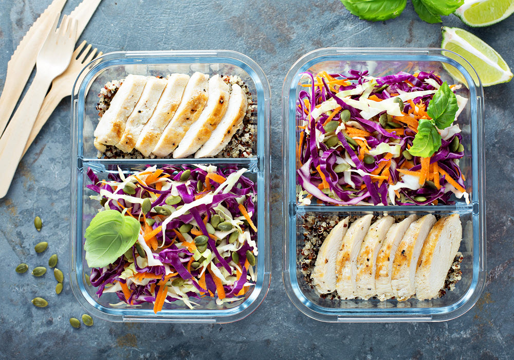 Two meal prep ready containers with chicken and salad.