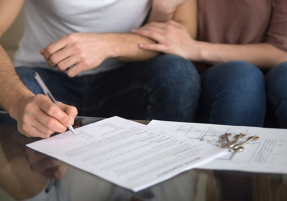 Couple doing paperwork to renew an apartment lease.