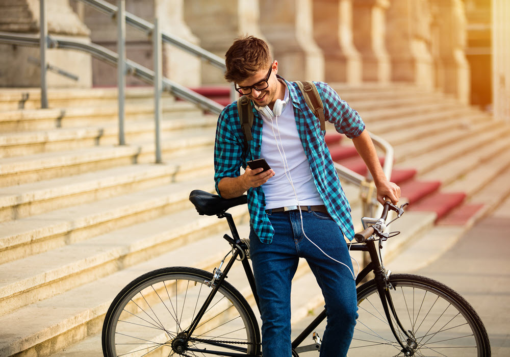 Boy looking at bike route on phone.