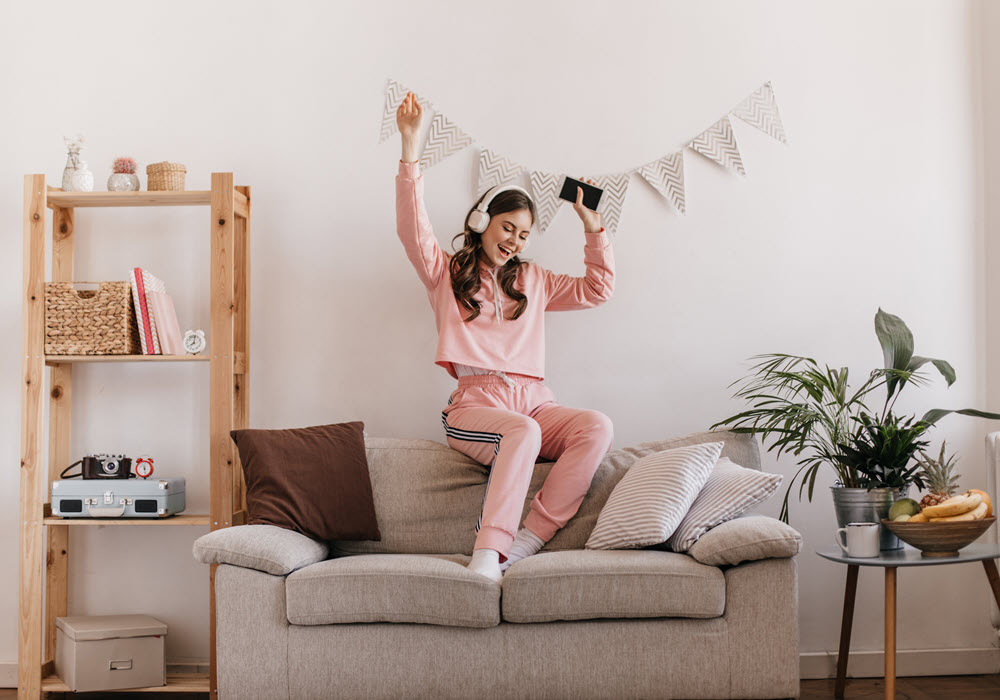 woman dancing on couch in apartment living room