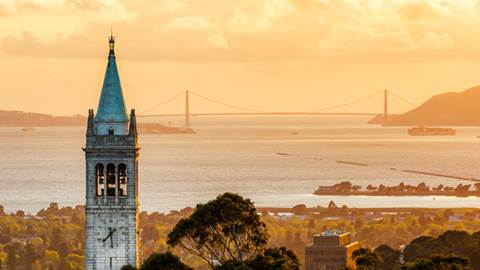 Berkeley's Sather Tower with view of bay and bridge in background.