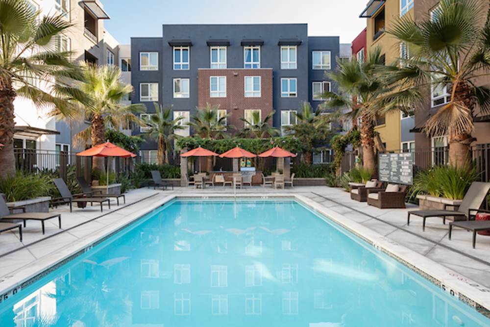 Outdoor swimming pool area with sundeck and lounge seating.