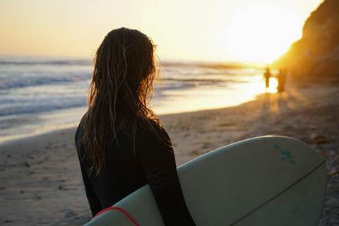 Surfer looking at sunset.