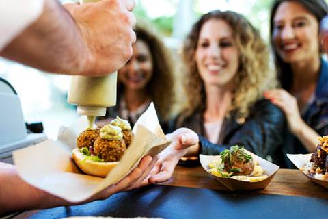 Chef serving snack to three women.