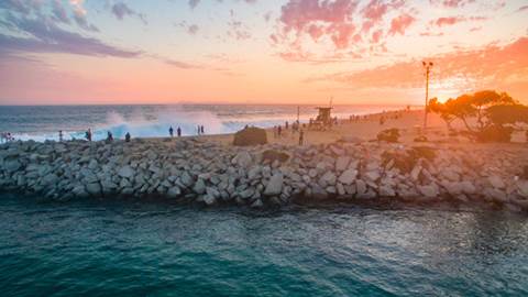 Rocky edge of beach at sunset.