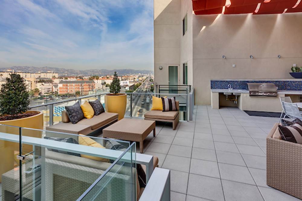 Rooftop terrace with lounge chairs overlooking the city.